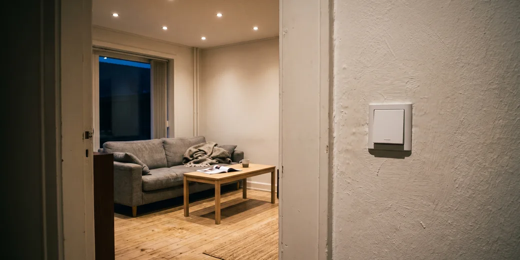 Wohnzimmer mit gedimmten Spots und einem normalen Lichtschalter
