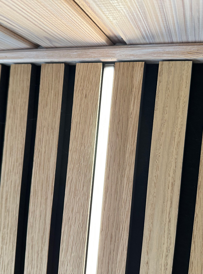 Akustikpaneel mit LED-Licht und Möbeln davor